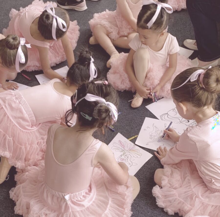 Dancers sitting together coloring after class
