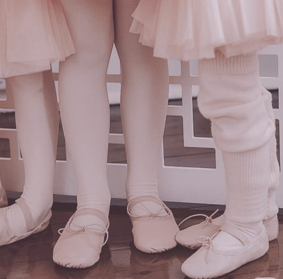 Close-up of young dancers' ballet shoes and tights